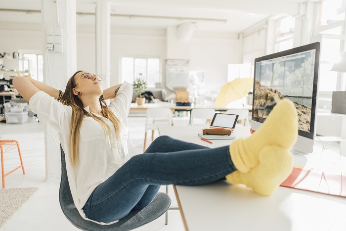 Woman relaxing at work with feet on top of her desk
